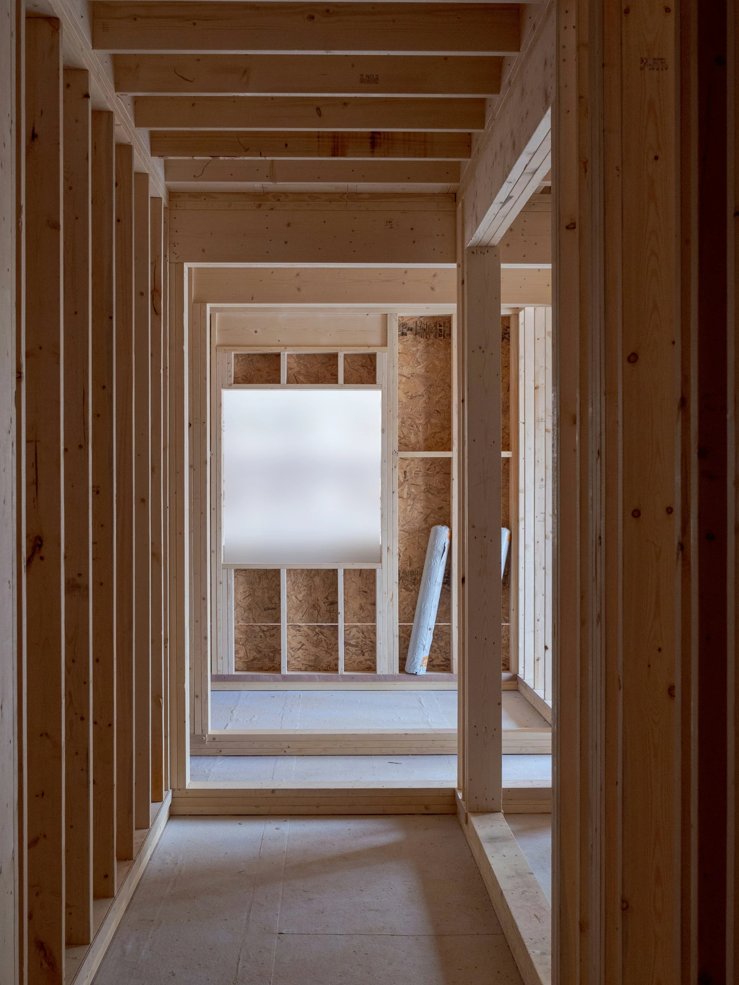 A framed hallway inside a new home, looking through to daylight