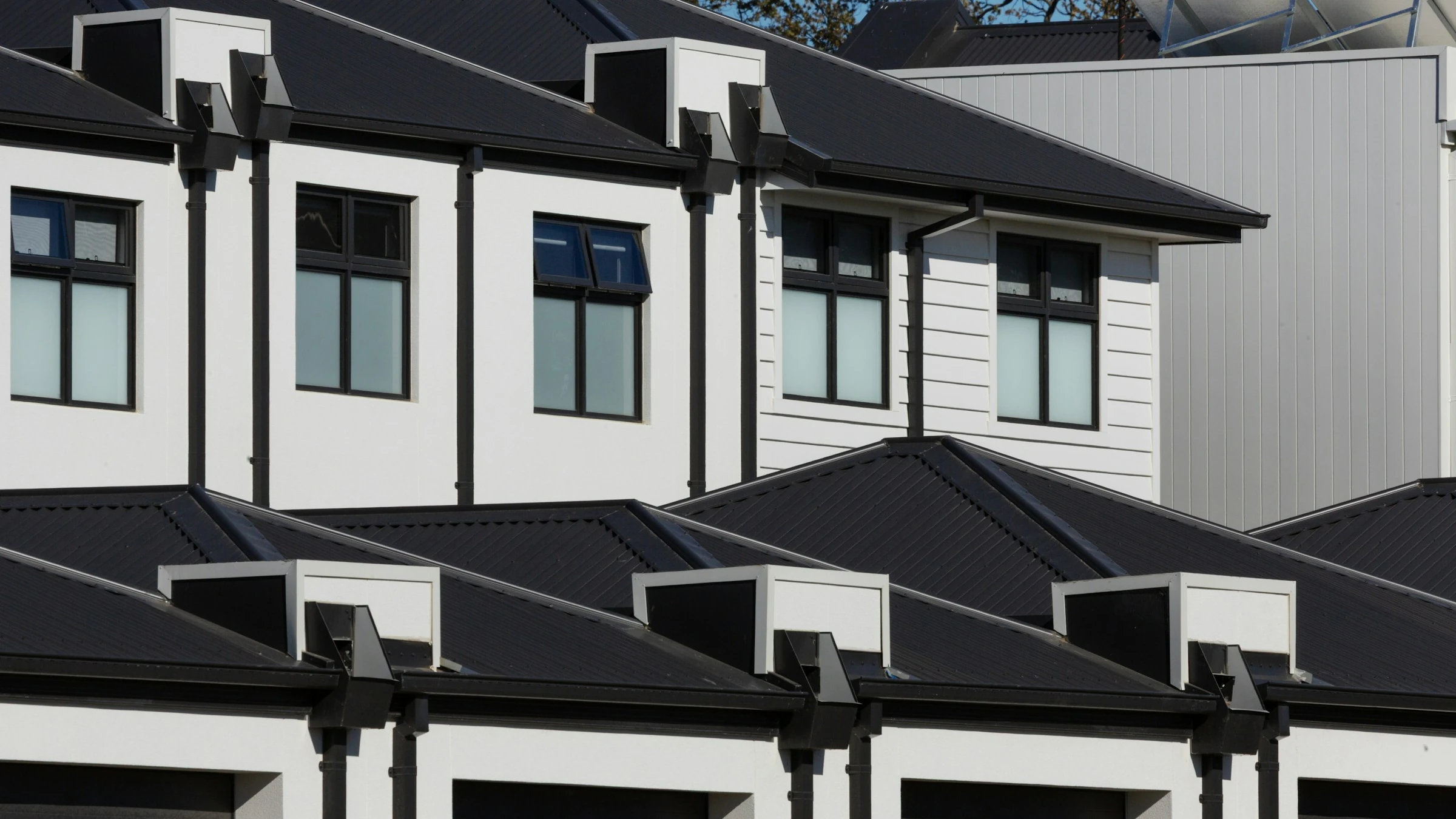 A row of modern townhomes with matching rooflines